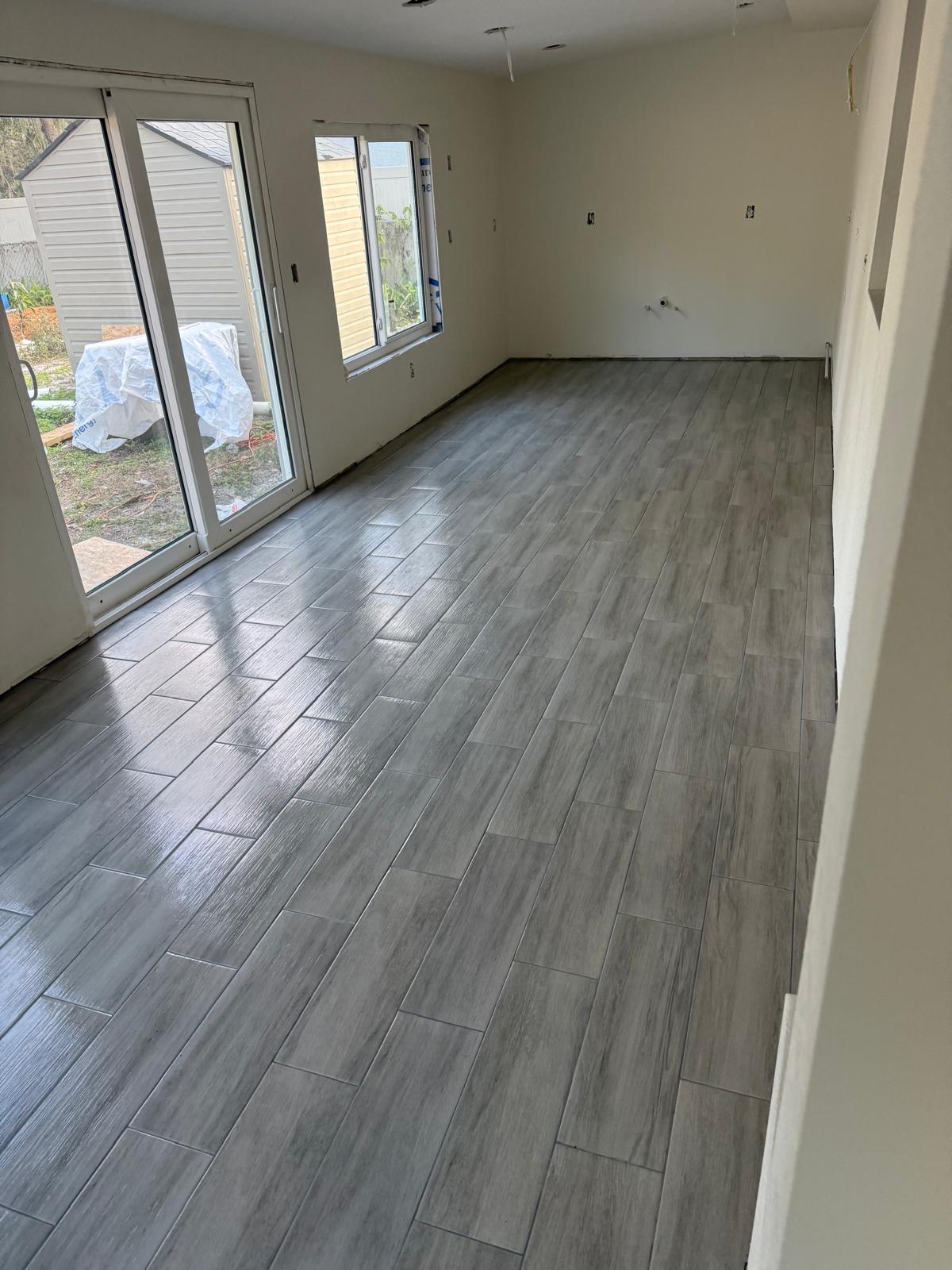 Grey wood-look plank tile in a room adjoining the lanai